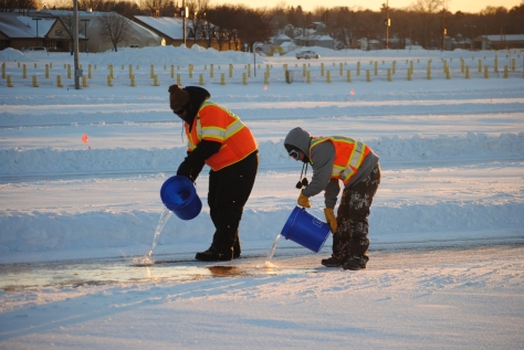 Students pour water to form ice on a test lane in Shakopee. 