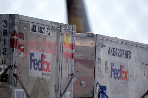 Metal FedEx containers at an airport.