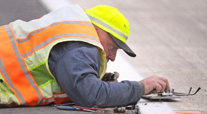 A pavement engineer checking instrumentation at the MnROAD test facility.