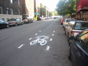 Pavement markings with directional arrows and a bicycle icon, called sharrows.