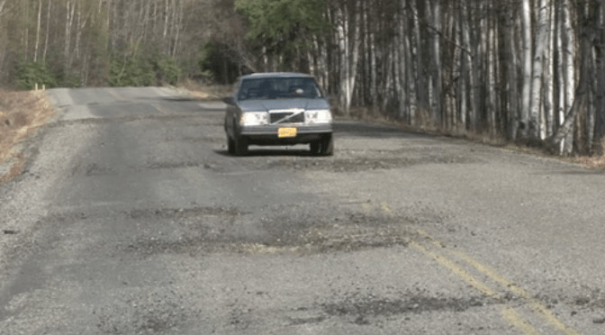 Car on road with frost damage