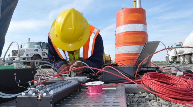 Researcher with a hardhat working with research equipment