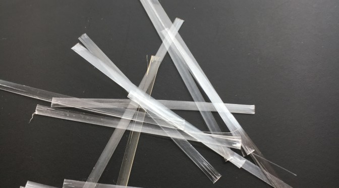 Synthetic fibers approximately 2 inches long compared to a ruler