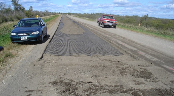 Truck and a car on a rural highway with geogrid applied to the road