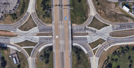 A bird’s-eye view of a diverging diamond interchange in Bloomington, Minnesota. Two diamond-shaped formations of many converging and diverging lanes of traffic are seen on either side of a multilane highway.