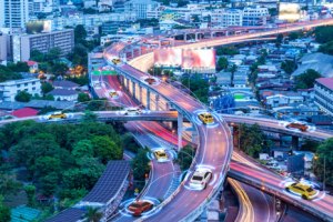 Aerial view of a city with autonomous and connected vehicles driving on freeways. 