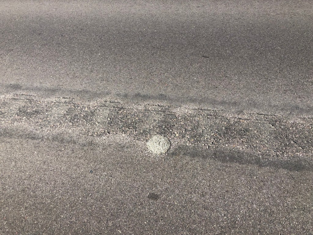 A dome of material fills the space of a lab core pulled from this pavement.