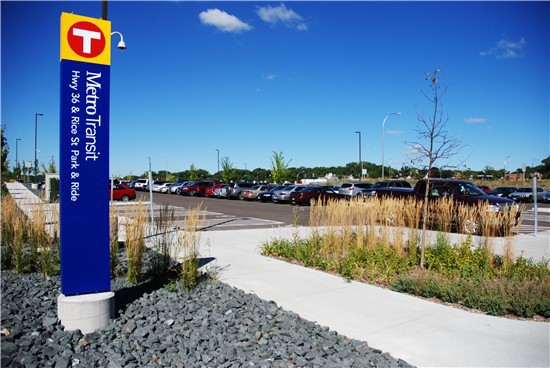 A park-and-ride sign for Metro Transit marks the corner of a large parking lot for transit users’ cars.