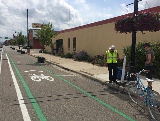 Worker installing a bicycle counter in a bike lane.