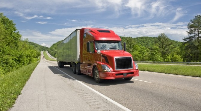 A large box truck on a highway.
