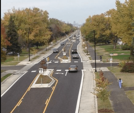 A road intersection with pedestrian crossings, bicycle lanes, median islands and left turn lanes.