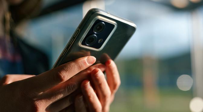 close up of hands holding a smartphone outdoors